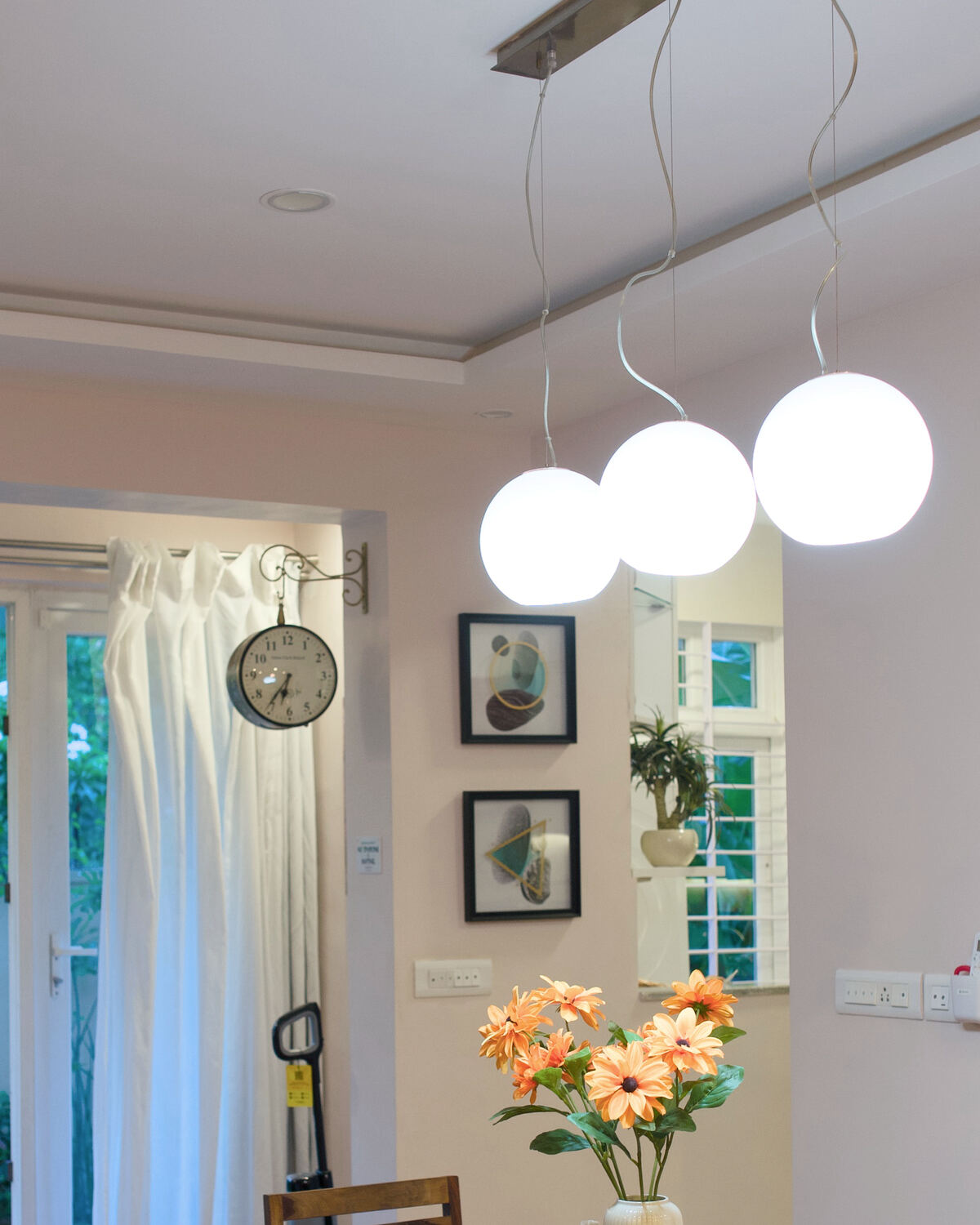Three glass pendant lamps glowing over the dining table